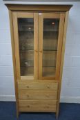 A JOHN LEWIS SOLID OAK BOOKCASE, the two glazed doors enclosing three adjustable glass shelves,
