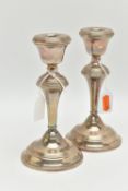 A PAIR OF SILVER CANDLE STICK HOLDERS, tapered polished form, on round weighted bases, approximate