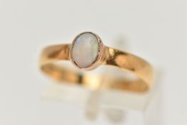 AN OPAL YELLOW METAL SINGLE STONE RING, set with an oval opal cabochon, within a milgrain setting,