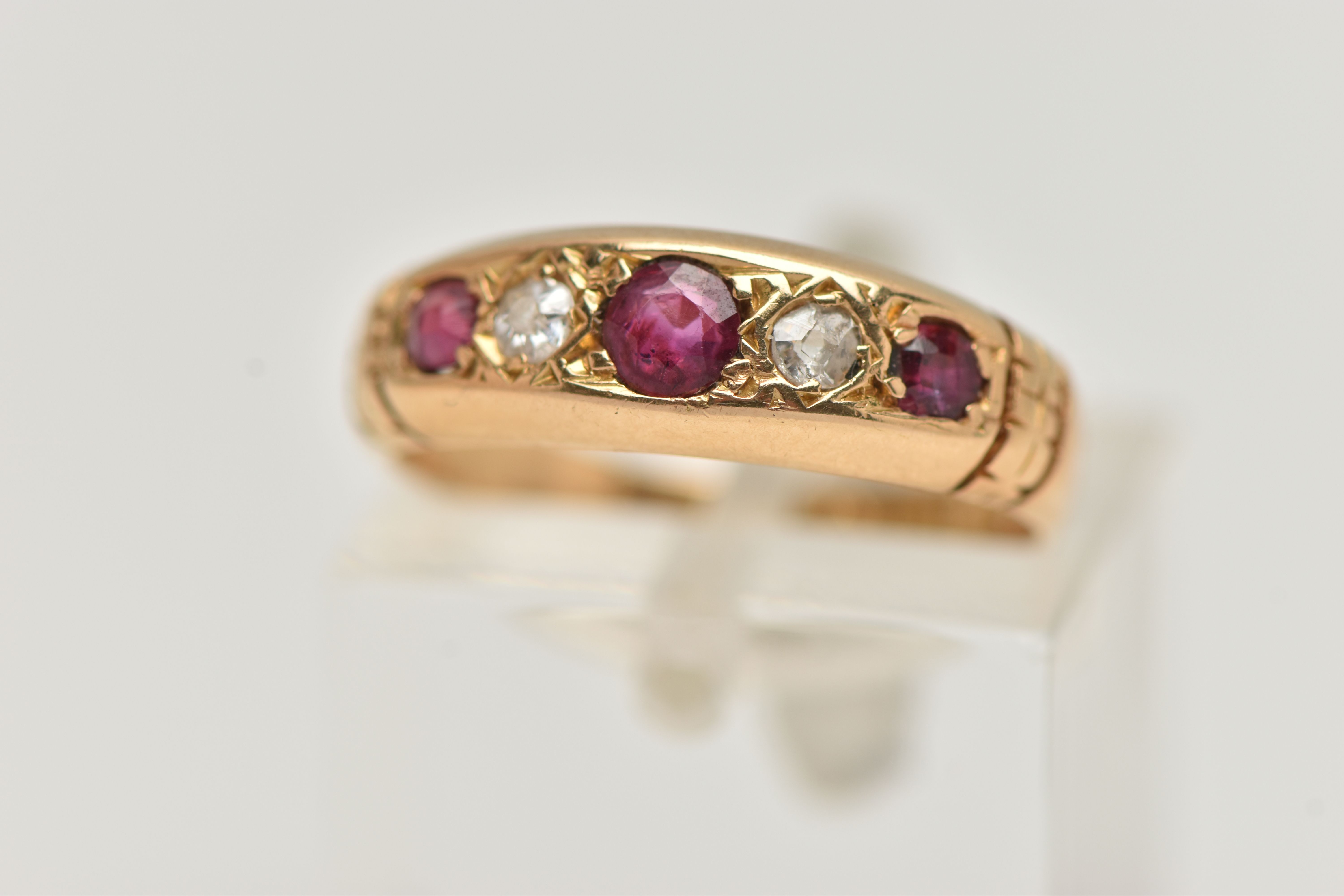 AN EARLY 20TH CENTURY, 18CT GOLD RUBY AND DIAMOND FIVE STONE RING, set with three circular cut