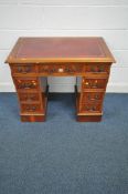 A REPRODUCTION YEW WOOD TWIN PEDESTAL DESK, with burgundy tooled leather writing surface, and an