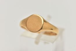 A YELLOW METAL SIGNET RING, plain round signet with tapered shoulders, stamped 18ct, ring size Q 1/