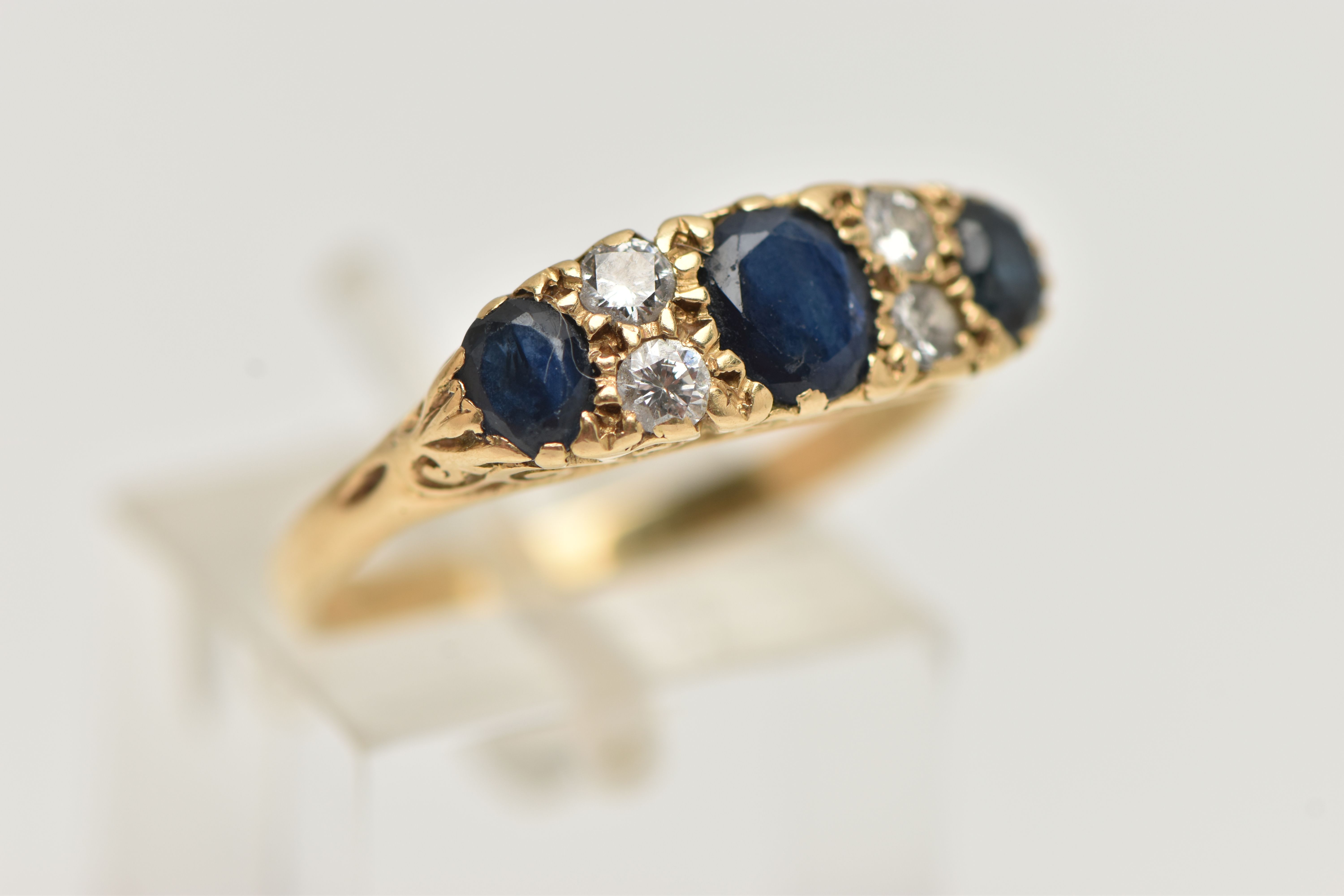 A YELLOW METAL SAPPHIRE AND DIAMOND RING, set with three oval cut deep blue sapphires, interspaced - Image 4 of 4