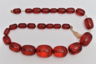 A SINGLE STRAND OF GRADUATED RED PLASTIC BEADS, twenty four oval red beads, largest measuring 29.1mm