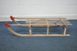 A VINTAGE GLOCO WOODEN SLED, with metal supports and red plastic caps, length 110cm (condition