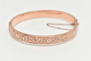 A EARLY 20TH CENTURY HINGED BANGLE, to include a rose gold flat hinged bangle with embossed floral