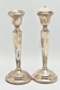 A PAIR OF SILVER CANDLE STICKS, tapered square columns on round weighted bases, hallmarks rubbed '