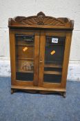 A 20TH CENTURY OAK SMOKERS CABINET, with raised top section, two bevelled glass doors enclosing