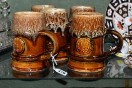 FIVE ZSOLNAY STONEWARE TANKARDS, designed by Gyorgy Furtos, each decorated with an applied panel