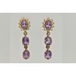 A PAIR OF YELLOW METAL AMETHYST AND SPLIT PEARL EARRINGS, comprised of an oval cut amethyst, prong