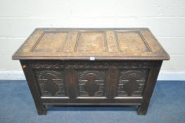 A GEORGIAN OAK COFFER, the hinged lid enclosing a candle box, three carved front panels, width 118cm