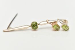 A PERIDOT BAR BROOCH AND EARRINGS, an oval cut peridot collet set in yellow metal with milgran