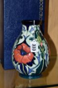 A BOXED MOORCROFT POTTERY 'POPPY' BALUSTER VASE, decorated with tube lined poppies on a dark blue-