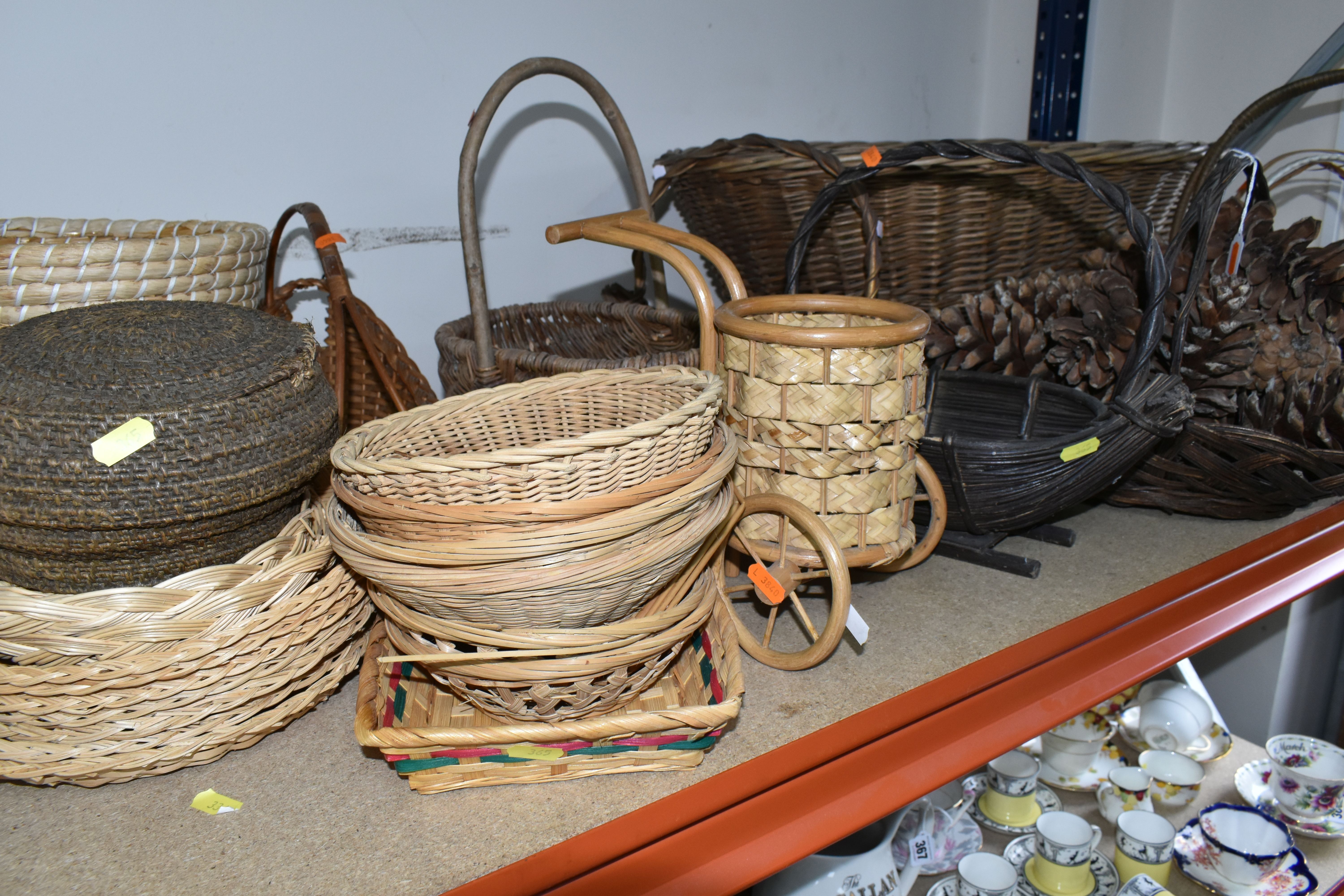 A QUANTITY OF WICKER BASKETS, to include an oval laundry basket, four flower baskets and a