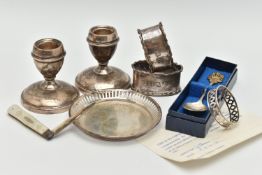A SELECTION OF SILVERWARE, to include a pair of dwarf candlesticks, a pair of napkin rings, a