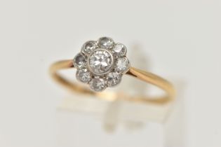 A DIAMOND CLUSTER RING, a principally set round brilliant cut diamond, bezel set in white metal, set