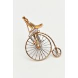 A 9CT GOLD PENNY FARTHING BROOCH, a white and yellow gold gentleman riding a penny farthing bicycle,