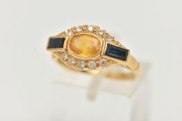 A SAPHIRE AND DIAMOND DRESS RING, a principally set oval cut yellow sapphire, set with blue baguette