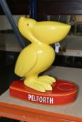 A PELFORTH BEER ADVERTISING DISPLAY FIGURE, yellow ceramic pelican figure on an oval red base with