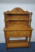 A MODERN PINE DRESSER, the top three tier plate rack with wheat decoration to crest, each shelf on