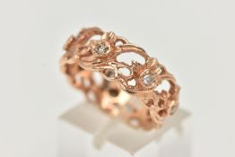A 14CT GOLD AND DIAMOND RING, a wide floral band with open work detail, set with seven prong set