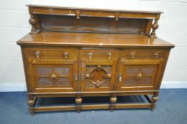 AN EARLY 20TH CENTURY OAK SIDEBOARD, with a raised back, three drawers above three cupboard doors,