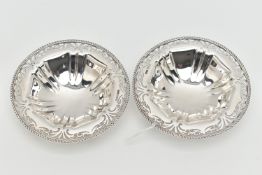 A PAIR OF GEORGE V SILVER CIRCULAR BONBON DISHES, with gadrooned rims and foliate pierced borders,