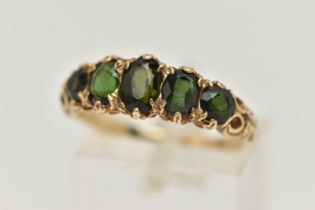 A 9CT GOLD GREEN TOURMALINE RING, designed as a row of three oval cut tourmaline, and two circular