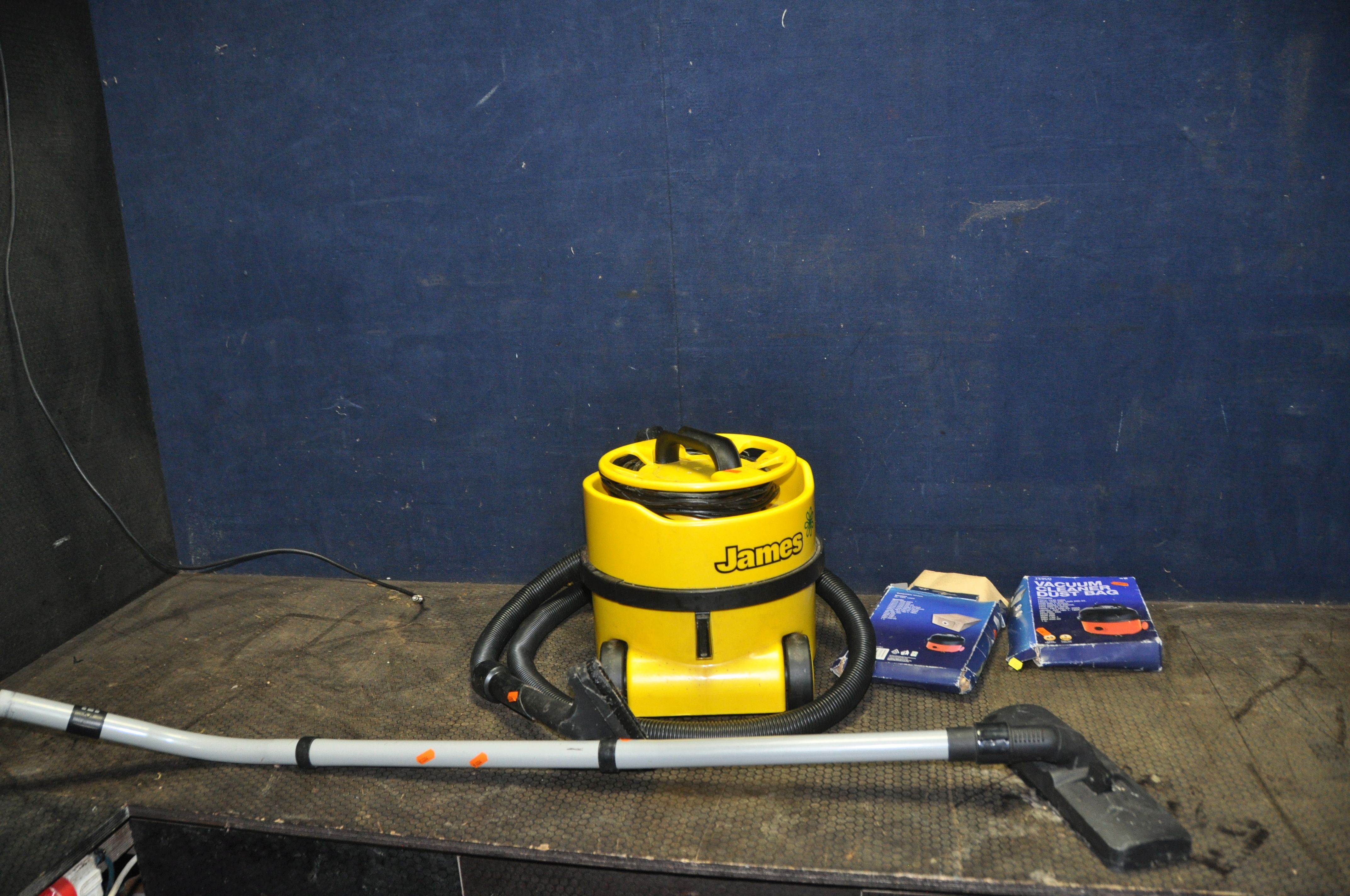 A NUMATIC 'JAMES' VACUUM CLEANER with pipework and spare bags (PAT pass and working)