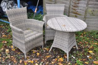 A DIAMOND DISTINCTION FAUX RATTAN CIRCULAR GARDEN TABLE AND CHAIRS, with cushions (condition report: