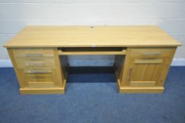 A SOLID OAK KNEE HOLE DESK, fitted with four pine lined drawers, a cupboard door and a central