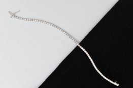 A 9CT WHITE GOLD DIAMOND LINE BRACELET, designed as sixty-four round brilliant cut diamonds each