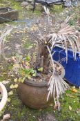 A LARGE WEATHERED COMPOSITE GARDEN PLANTER, containing a plant, diameter 56cm x height 45cm (