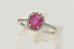 AN 18CT WHITE GOLD RUBY AND DIAMOND RING, set with an oval cut ruby, in a halo of round brilliant