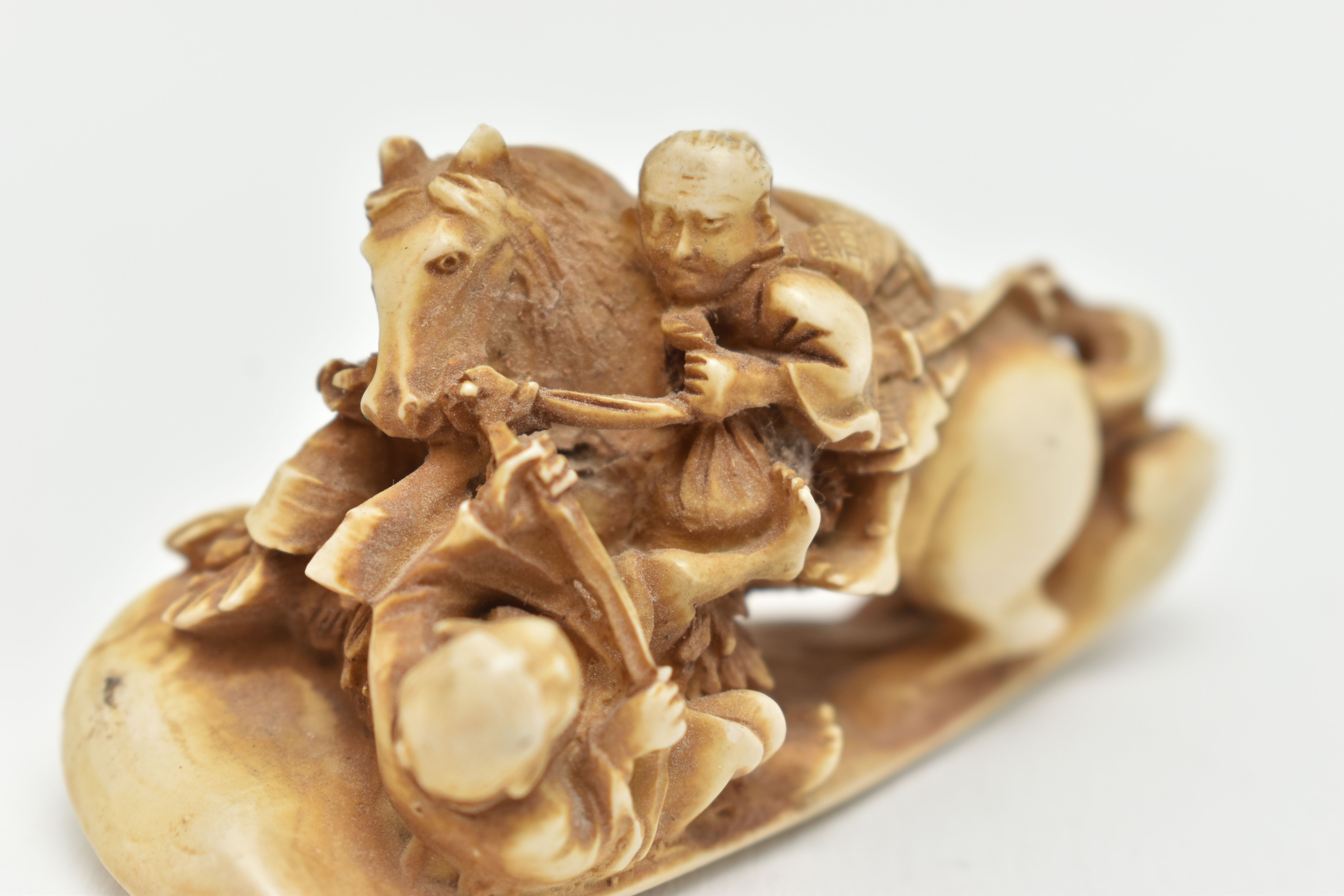 A BONE OKIMONO, a carved ornament depicting a man on a horse over a fallen down man, approximate - Image 5 of 7