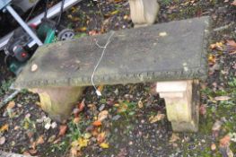 A WEATHERED COMPOSITE RECTANGULAR GARDEN BENCH, on twin scrolled supports, length 119cm depth 41cm x