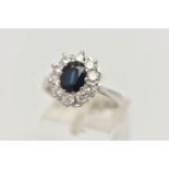 AN 18CT WHITE GOLD SAPPHIRE AND DIAMOND CLUSTER RING, the oval sapphire within a ten claw setting