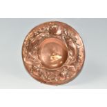 AN ARTS & CRAFTS NEWLYN COPPER PLATE, the rim embossed with a pattern of fish, seaweed and shells,