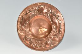 AN ARTS & CRAFTS NEWLYN COPPER PLATE, the rim embossed with a pattern of fish, seaweed and shells,