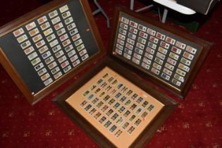 THREE FRAMED AND GLAZED DISPLAYS OF MILITARY CAP BADGES AND KINGS COLOURES, the cards include one