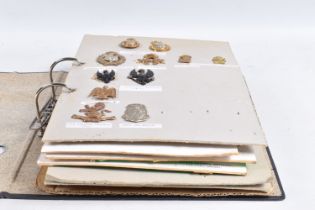 A BINDER CONTAINING VARIOUS CAP BADGES AND COLLAR BADGES FROM VARIOUS ERAS, these include brass