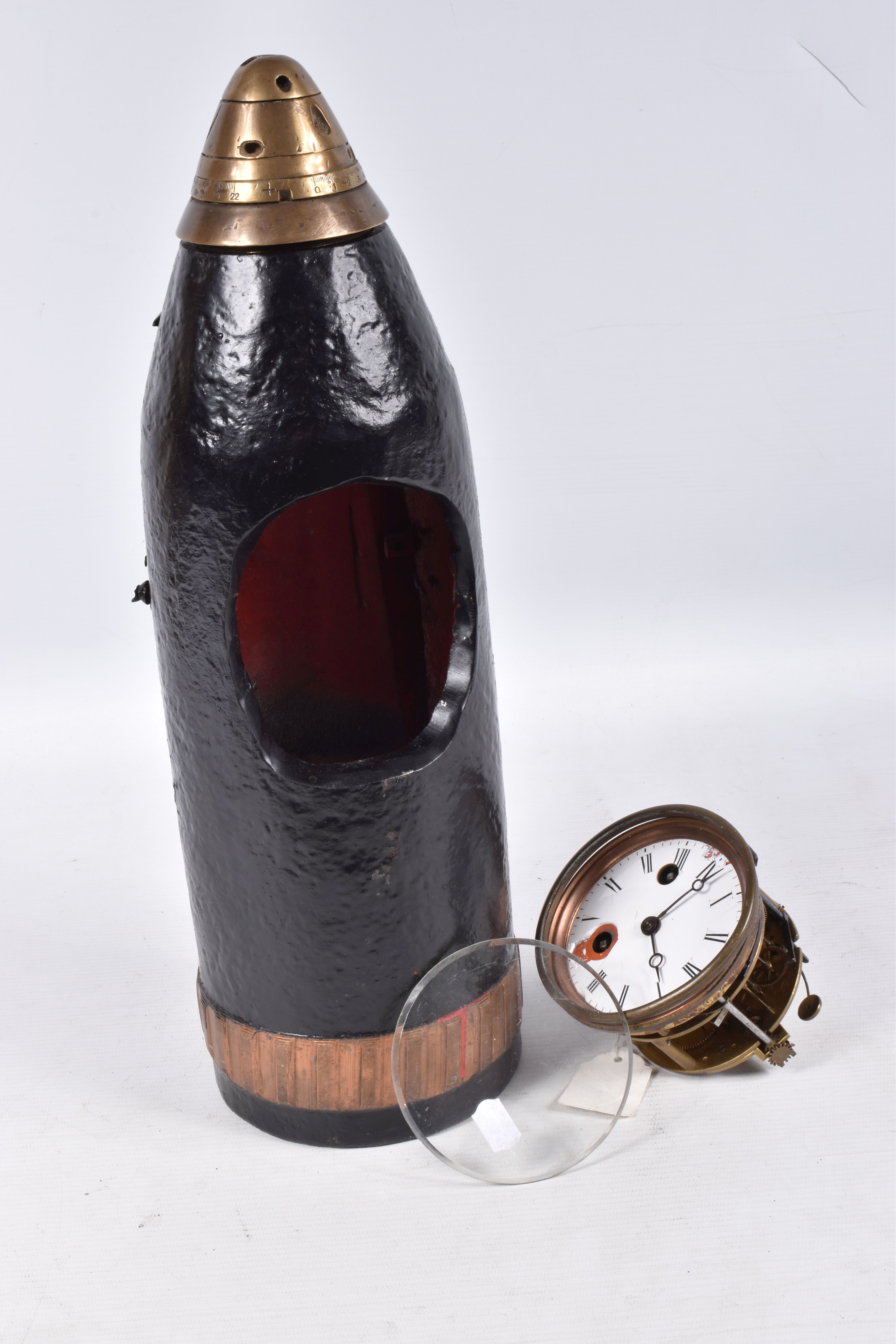 A TRENCH ART MANTLE CLOCK FORMED FROM A BOMB CASING, 19th century movement free from the case,