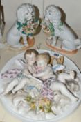 A PORCELAIN PLAQUE DEPICTING A PAIR OF CHERUBS, AND TWO GERMAN SPANIEL FIGURES, the circular