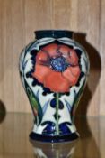 A MOORCROFT POTTERY BALUSTER VASE DECORATED WITH POPPIES ON A PALE GREEN AND DARK BLUE GROUND, circa