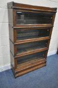 AN OAK GLOBE WERNICKE FOUR TIER SECTIONAL BOOKCASE, each section with bevelled glass hide and fall