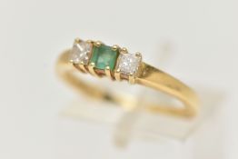 AN 18CT GOLD EMERALD AND DIAMOND THREE STONE RING, two princess cut diamonds set either side of a