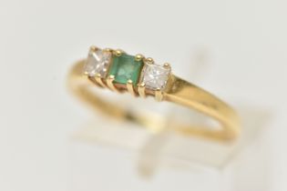 AN 18CT GOLD EMERALD AND DIAMOND THREE STONE RING, two princess cut diamonds set either side of a