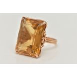 A CITRINE RING, designed as a large rectangular citrine in a four claw setting to the loop design