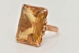 A CITRINE RING, designed as a large rectangular citrine in a four claw setting to the loop design