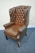 A BROWN LEATHER BUTTONED WING BACK ARMCHAIR, with studded detail, width 79cm x depth 86cm x height